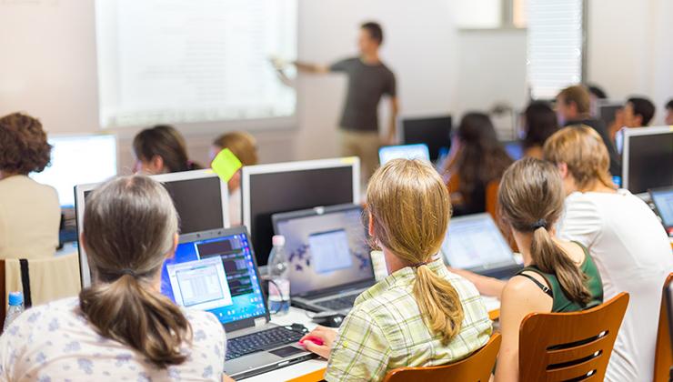 Students sit in front of their laptops during a lecture